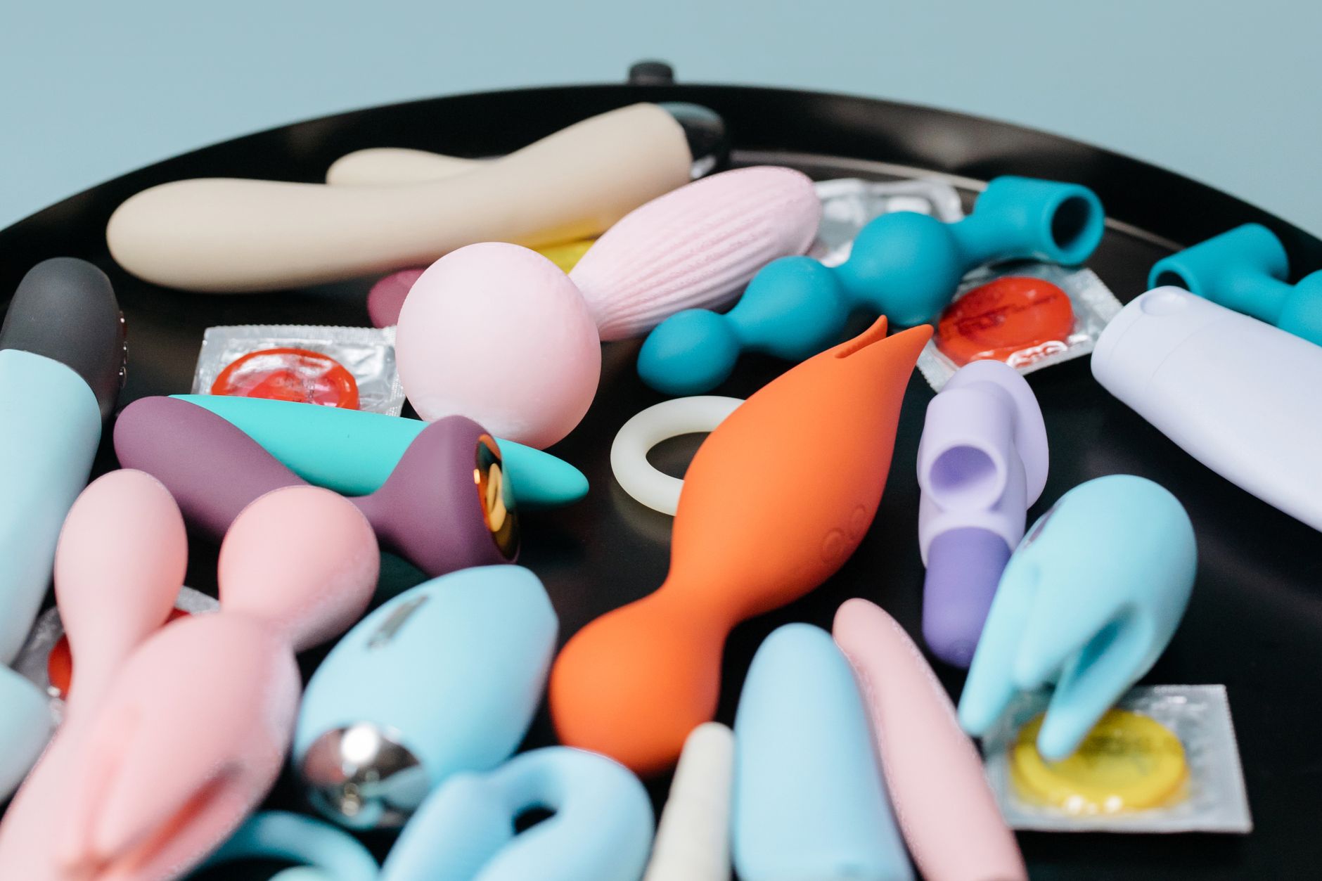 Person holding blue and pink silicone vibrators with confidence