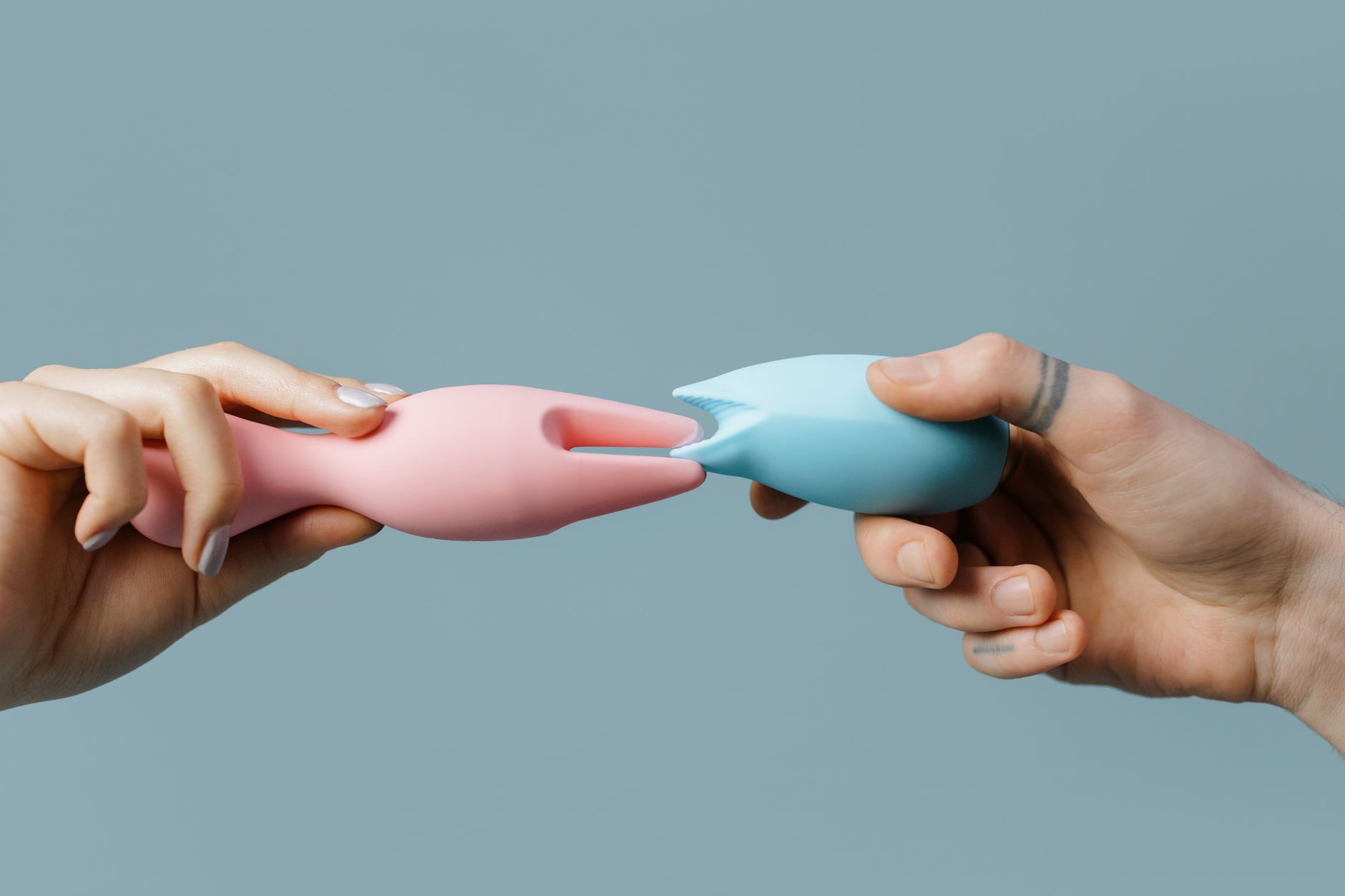 Hand holding a vibrator against a purple backdrop, ready for intimate moments.