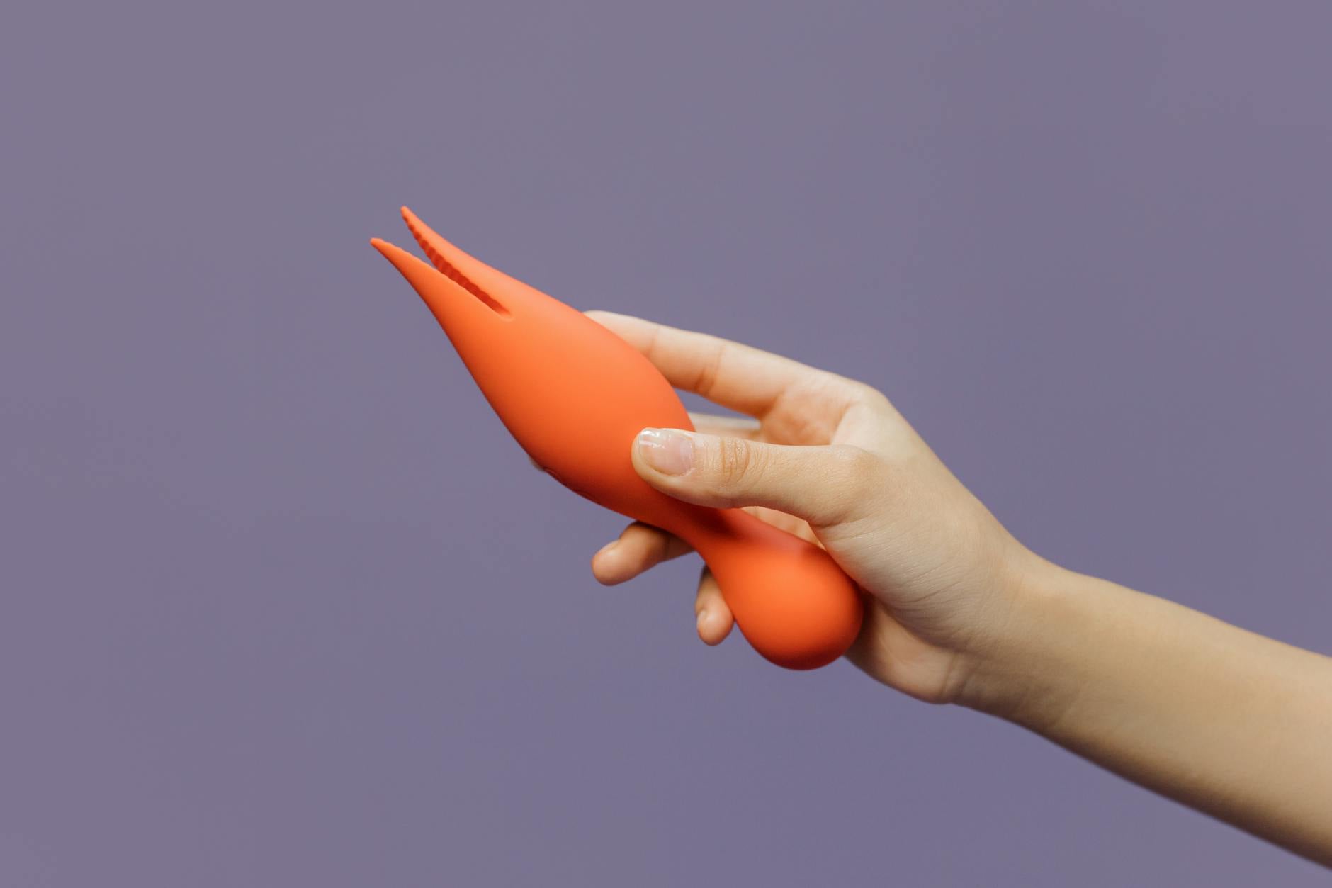 Close-up of hands holding a lemon-colored vibrator, showcasing intimate exploration and sensual discovery