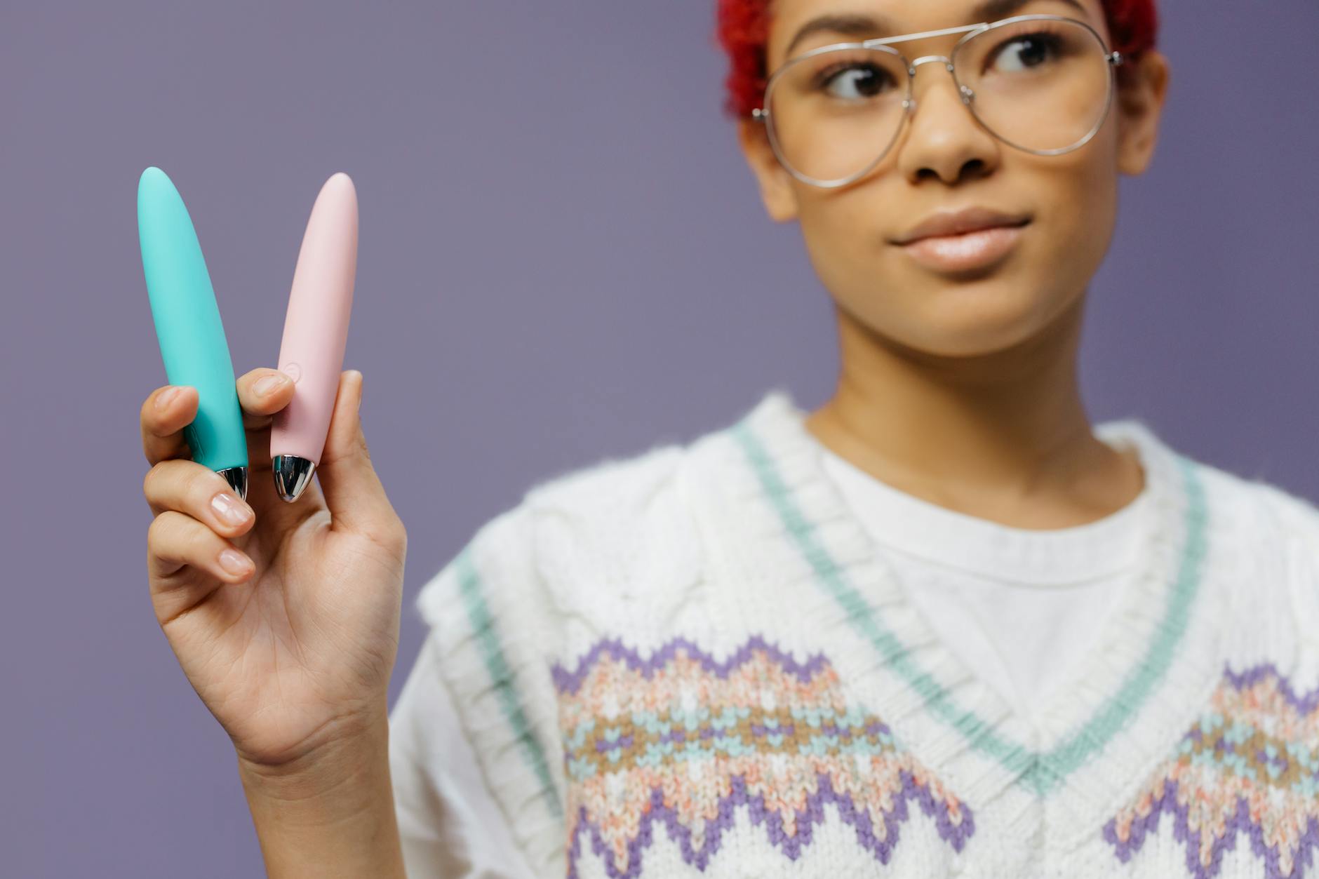 A person holding colorful vibrators representing reconnection and personal pleasure after relationship trauma