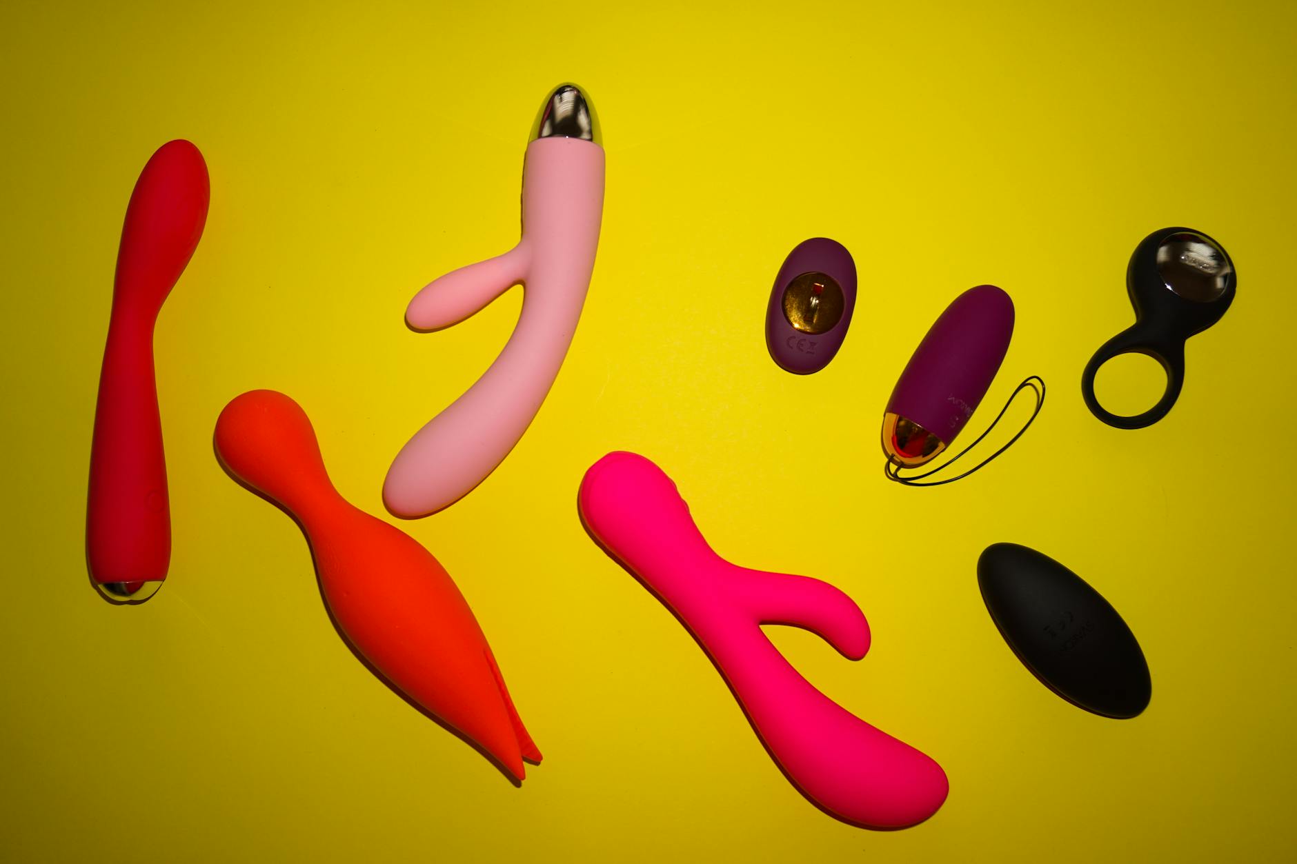 Hand holding a vibrator against a purple backdrop, showing modern approach to clitoral pleasure
